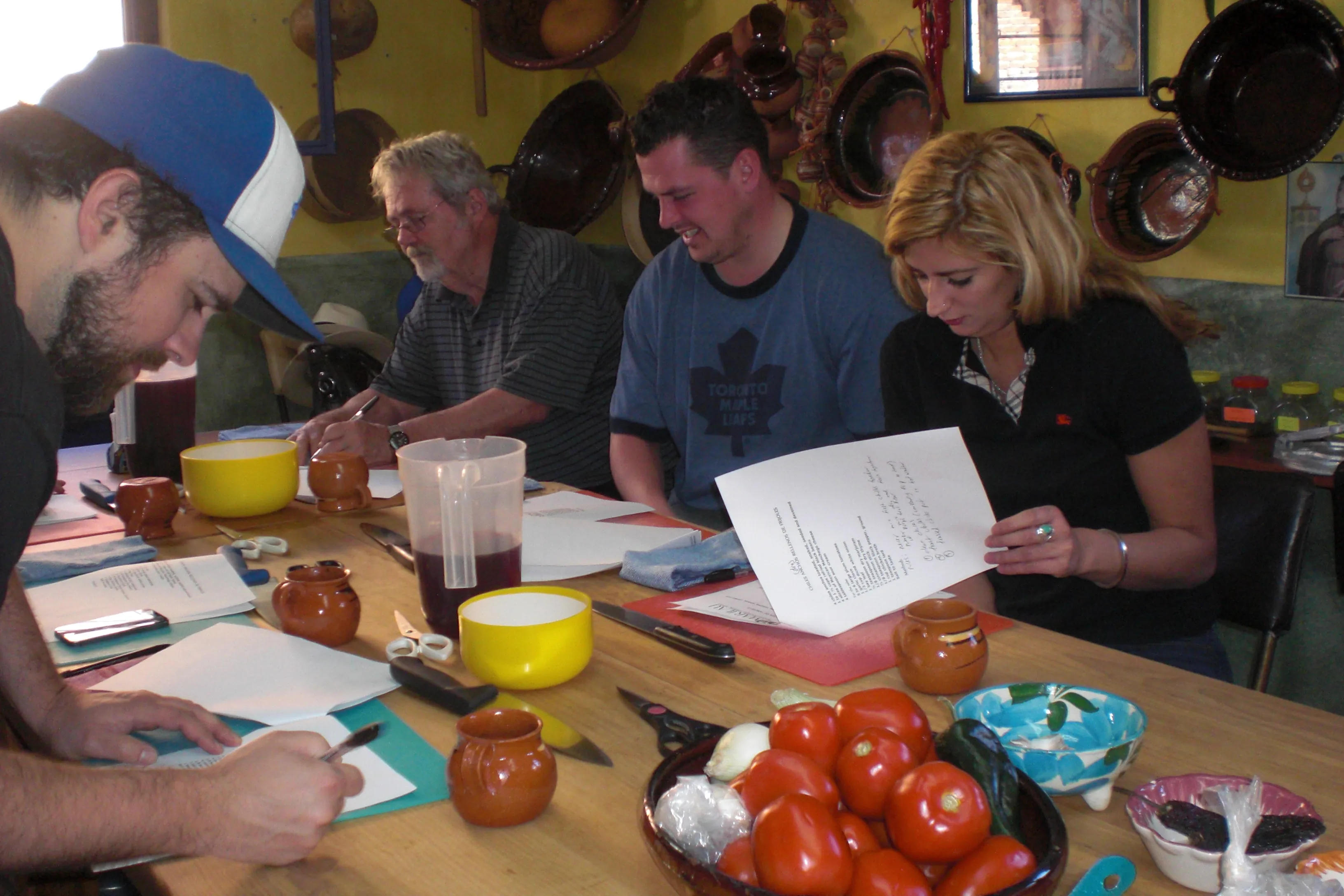 Students reading their printed recipes around the class table