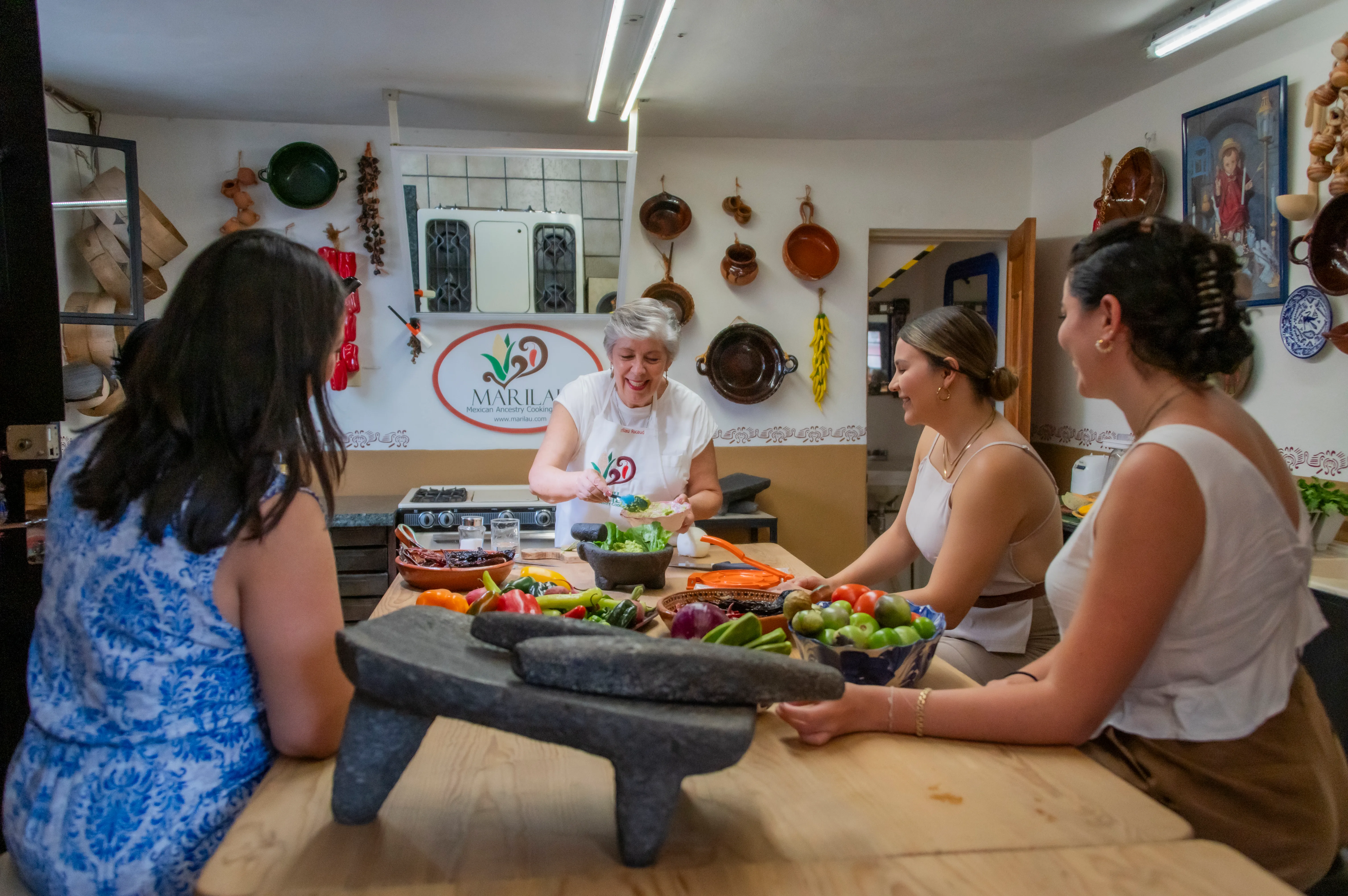 Marilau and her students cooking together around the class table in San Miguel de Allende