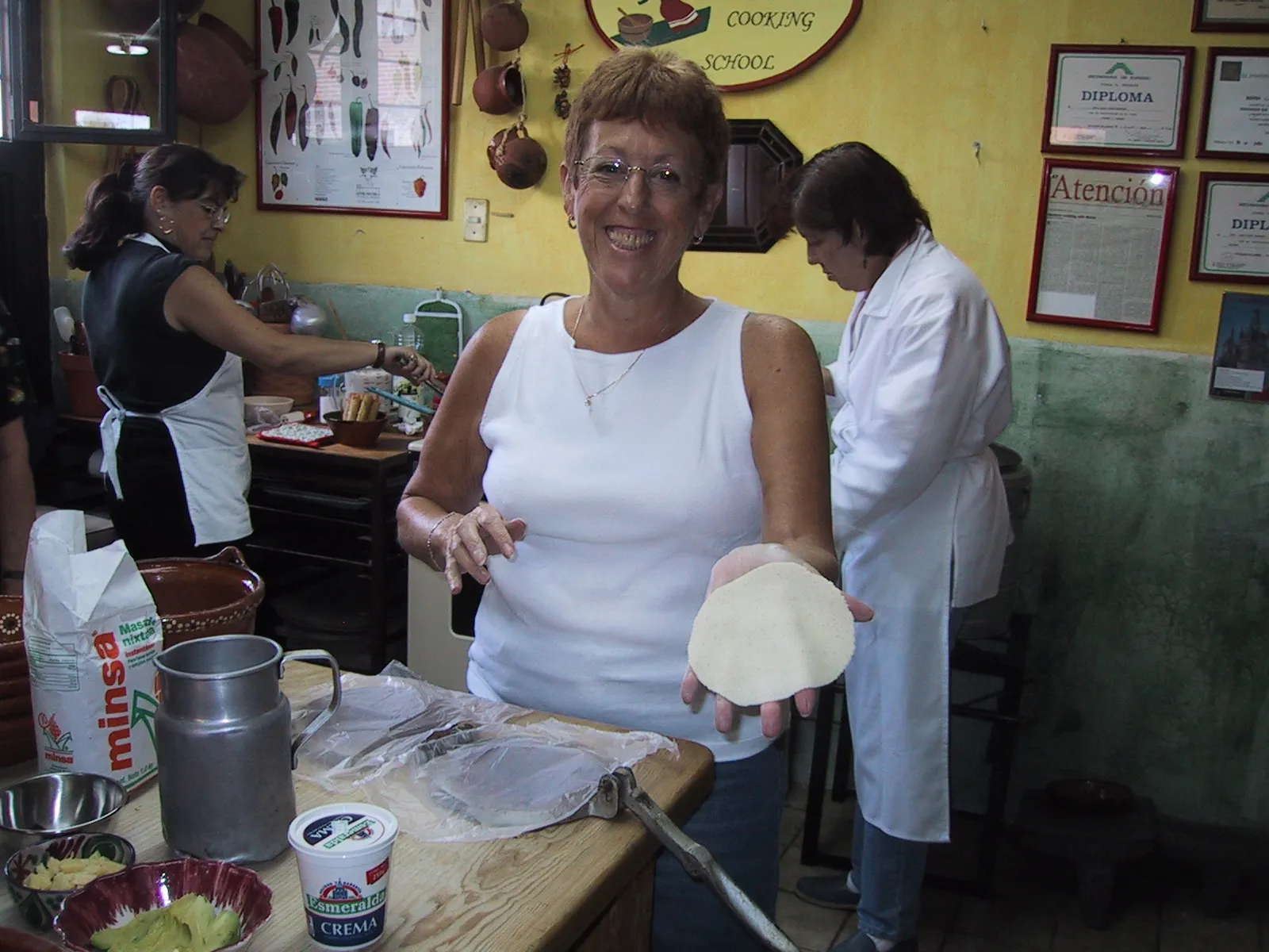A student proudly shows the first tortilla she pressed