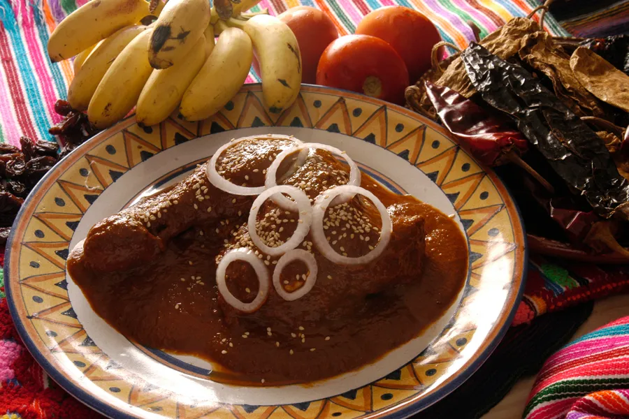 Mole poblano with onion rings and sesame seeds on a talavera plate