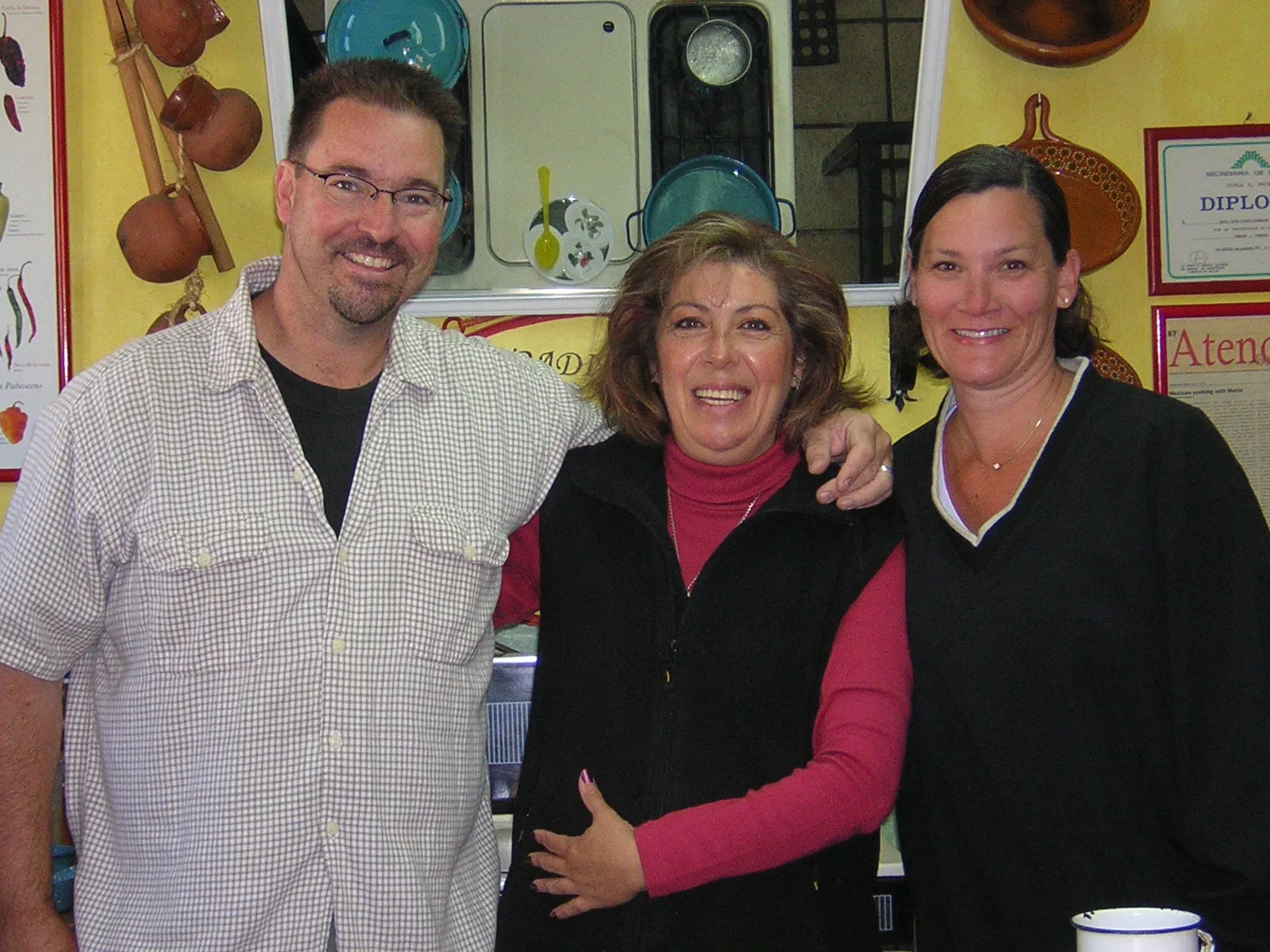 Two students with Marilau in the old kitchen